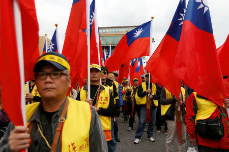 Protesters hold Taiwanese national flags as they take part in a rally against the overhaul of the military and civil service pension fund, outside the Presidential Office in Taipei,Taiwan January 22, 2017. REUTERS/Tyrone Siu