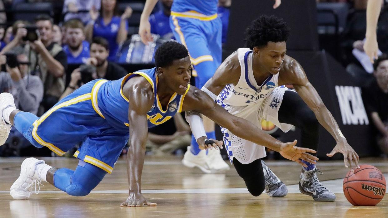 Mandatory Credit: Photo by AP/Shutterstock (8553005ab)Kentucky guard De'Aaron Fox and UCLA guard Aaron Holiday chase a loose ball in the second half of an NCAA college basketball tournament South Regional semifinal game, in Memphis, TennNCAA UCLA Kentucky Basketball, Memphis, USA - 24 Mar 2017.