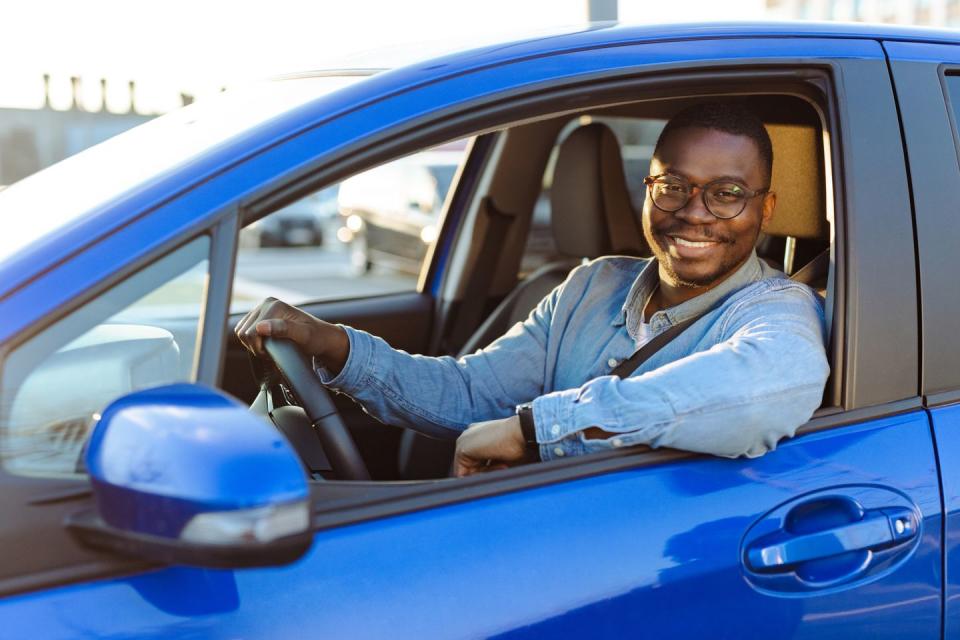 portrait of a cheerful male driver in the car