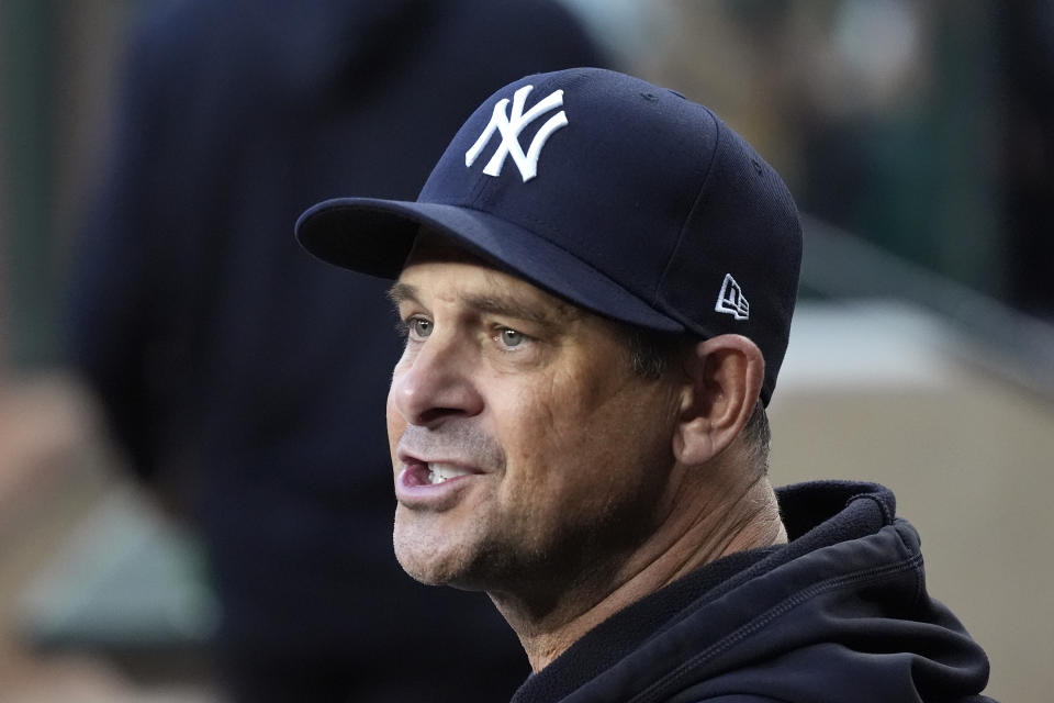 New York Yankees manager Aaron Boone talks with a player in the dugout during the first inning of a baseball game against the Arizona Diamondbacks Tuesday, April 2, 2024, in Phoenix. (AP Photo/Ross D. Franklin)