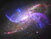 This composite image made available by NASA shows the galaxy NGC 4258, also known as M106, about 23 million light-years away from Earth. Two extra spiral arms glow in X-ray, optical, and radio light. These anomalous arms are not aligned with the plane of the galaxy. The data was captured by the NASA's Chandra X-ray Observatory, the National Science Foundation's Karl Jansky Very Large Array, the Hubble Space Telescope and the Spitzer Space Telescope. (NASA/CXC/JPL-Caltech/STScI/NSF/NRAO/VLA via AP)