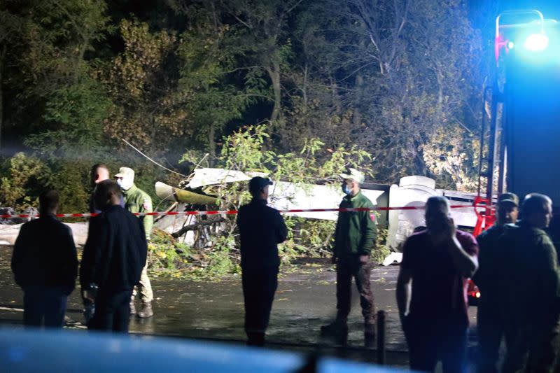 Rescuers inspect wreckages of the Ukrainian military Antonov An-26 plane after crashing outside of Chuhuiv town