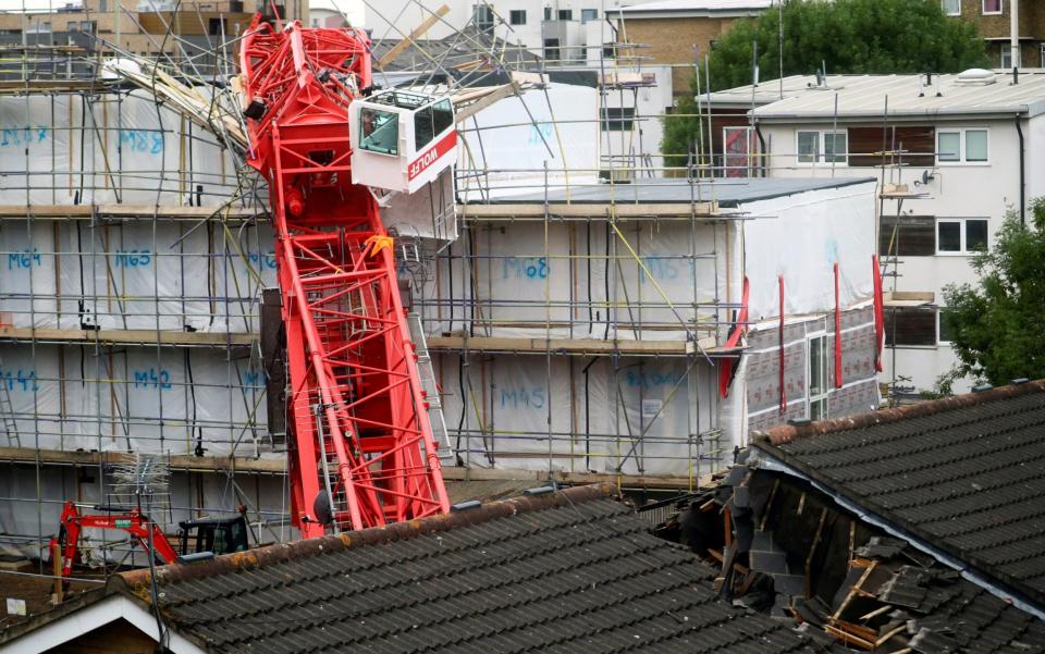 The crane collapsed on a site where flats are being constructed, crashing onto two adjacent houses - Hannah McKay/Reuters