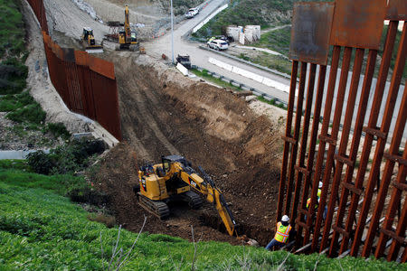 Construction workers in the U.S. work on a new section of the border fence as seen from Tijuana, Mexico February 18, 2019. REUTERS/Jorge Duenes