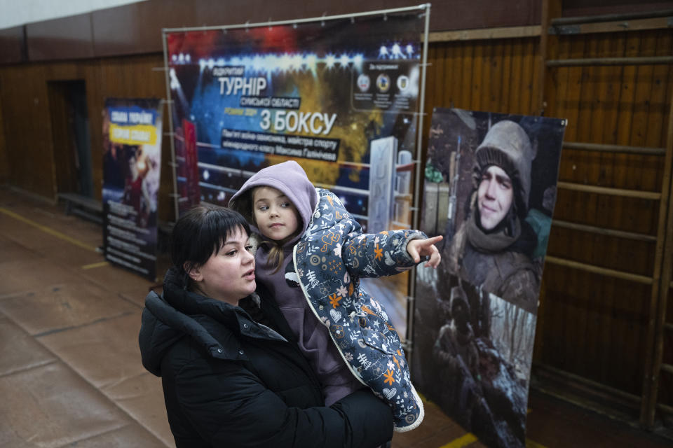 Vasilisa plays with her mother, Polina Ihrak, during a boxing tournament in honor of her father, Maksym Halinichev, who was killed during fighting with Russian forces in March 2023, in Romny, Sumy region, Ukraine on Saturday, Feb. 3, 2024. “I have a little child. I don’t want her to live in occupation among the aggressor, among the Russians,” Halinichev told one of his coaches. (AP Photo/Evgeniy Maloletka)