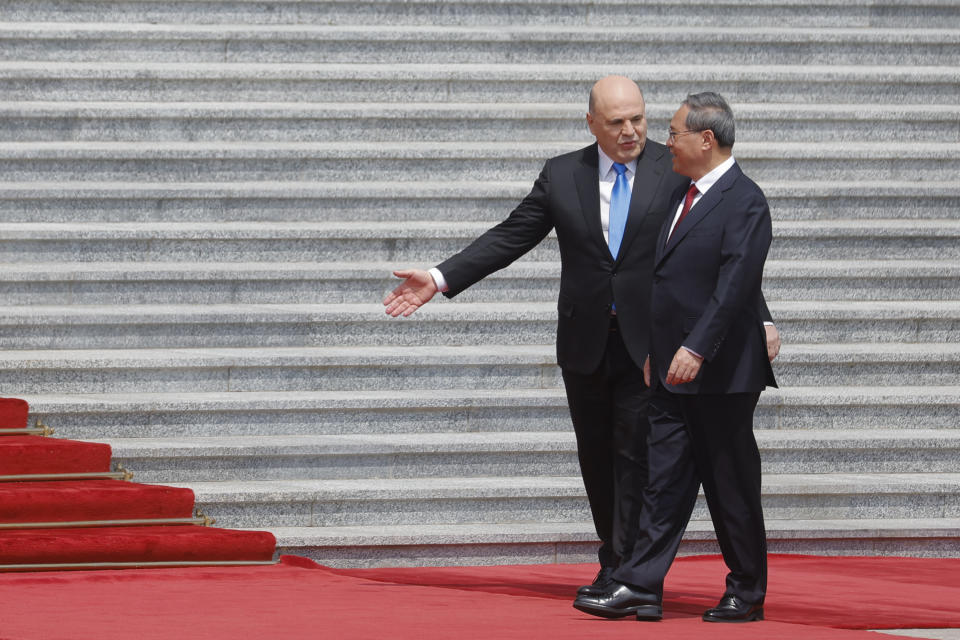 Russian Prime Minister Mikhail Mishustin, left, and Chinese Premier Li Qiang attend a welcoming ceremony in Beijing, China, Wednesday, May 24, 2023. (Thomas Peter/Pool Photo via AP)