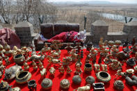 A souvenir vendor takes a nap in front of barbed wire marking the border between North Korea and China, just north of Dandong in China's Liaoning province, April 2, 2017. REUTERS/Damir Sagolj