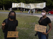 Two women strike a pose as they leave after taking part in a demonstration in The Hague, Netherlands, Tuesday, June 2, 2020, to protest against the recent killing of George Floyd, police violence and institutionalized racism. Floyd, a black man, died in police custody in Minneapolis, U.S.A., after being restrained by police officers on Memorial Day. (AP Photo/Peter Dejong)