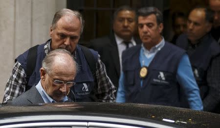 Rodrigo Rato, former People's Party minister and former managing director of the International Monetary Fund, enters a police's car as they leave his residence after an inspection in Madrid, April 16, 2015. REUTERS/Sergio Perez