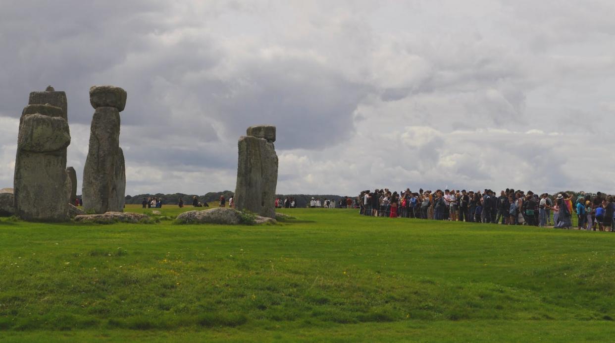 Stonehenge, en Inglaterra, con los visitantes en segundo plano. <a href="https://www.shutterstock.com/es/image-photo/salisbury-plain-wiltshire-uk-08-12-2348556659" rel="nofollow noopener" target="_blank" data-ylk="slk:David JC/Shutterstock;elm:context_link;itc:0;sec:content-canvas" class="link ">David JC/Shutterstock</a>