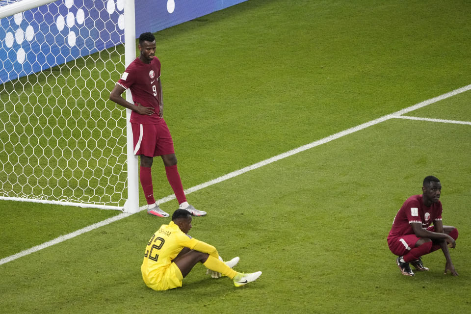 FILE - Qatar's Mohammed Muntari, left, and Qatar's goalkeeper Meshaal Barsham look on after the World Cup group A soccer match between Qatar and Senegal, at the Al Thumama Stadium in Doha, Qatar, Friday, Nov. 25, 2022. Senegal won 3-1. Qatar became the first host nation in World Cup history to lose the opening match, and then only the second host to be eliminated from the group stage. South Africa in 2010 was the first host nation to be eliminated in group stage but still had a chance to advance in its third and final group match. (AP Photo/Ariel Schalit, File)