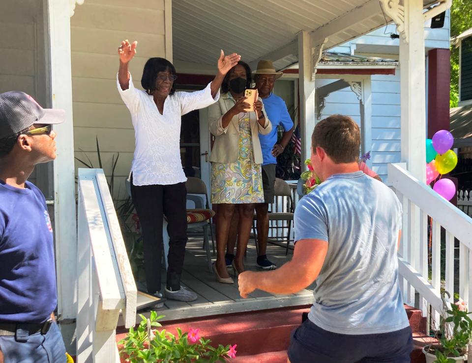 Cora Tyson reaches out to hug a man as he delivers flowers to her during a birthday procession held on Wednesday, her 99th birthday, in front of her Lincolnville home. Family, friends and church members attended. Tyson, who is regularly mentioned on trolley tours, provided shelter to Martin Luther King Jr. at the same home during the civil rights movement.