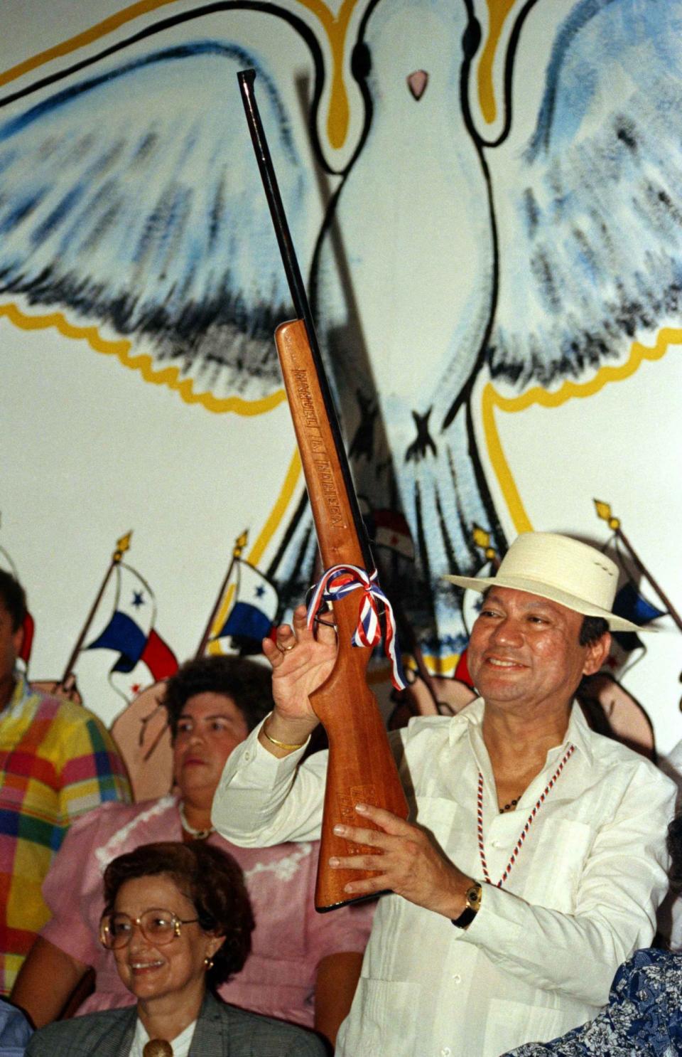 <p>Gen. Manuel Noriega holds a rifle bearing his name, given to him by a supporter during a pro-government rally, in Santiago, Panama, Oct. 5, 1989. (AP Photo/Matias Recart) </p>