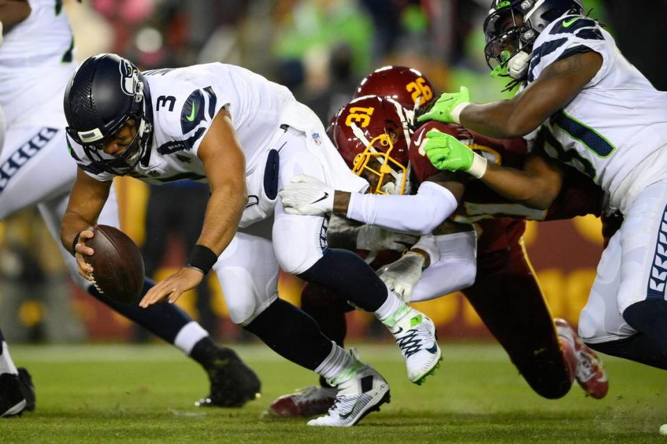 Seattle Seahawks quarterback Russell Wilson (3) is taken down by Washington Football Team free safety Kamren Curl (31) during the second half of an NFL football game, Monday, Nov. 29, 2021, in Landover, Md. (AP Photo/Nick Wass)