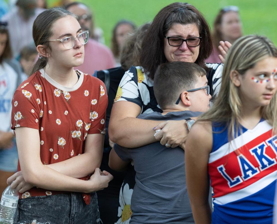 Families hug and shed tears during a vigil Saturday for the Dunham family at Hartville Memorial Park. All five members of the family died in what investigators describe as a homicide-suicide.
