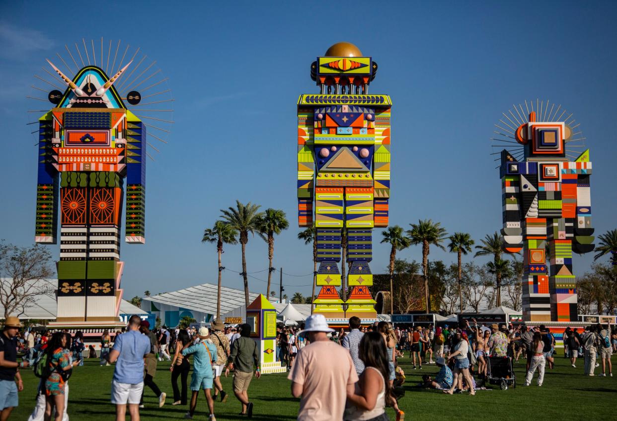 The three figures that make up "The Messengers" by Kumkum Fernando are seen from a distance during the Coachella Valley Music and Arts Festival at the Empire Polo Club in Indio, Calif., Friday, April 14, 2023.