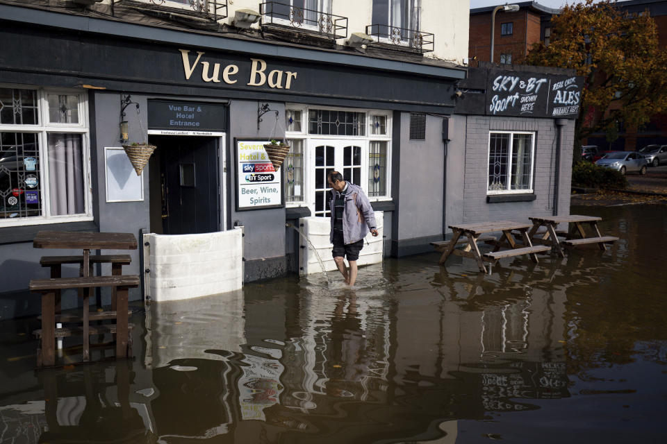 A staff member walks outside the flooded Vue Bar in Worcester, after Britain has been hit by widespread flooding after rivers burst their banks following the weekend's heavy rain, Monday, Oct. 28, 2019. (Jacob King/PA via AP)