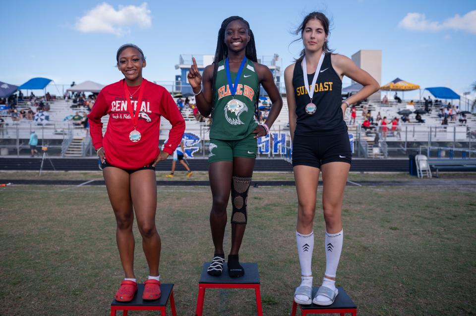 Long jump second place medalist Adina Jackson, Palm Beach Central, first place medalist Lakesha Smith, Atlantic, and third place medalist Helina Hoim, Suncoast, pose for a picture with their medals during the Palm Beach County Track and Field Championships at Spanish River High School on Thursday, April 6, 2023, in Boca Raton, Fla.