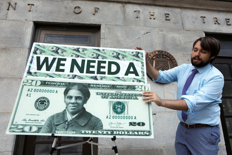 In 2019, a Capitol Hill staff member places signs before a news conference by House Majority Leader Steny Hoyer (D-M.D.) on then-Treasury Secretary Steve Mnuchin's decision to indefinitely delay putting Harriet Tubman on the new $20 bill. (Photo: Yuri Gripas / Reuters)