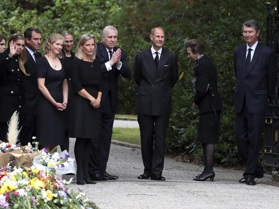 From left, Britain's Princess Eugenie, Peter Phillips, Lady Louise Windsor, Zara Tindall, Sophie Countess of Wessex, Prince Andrew, Prince Edward, Princess Anne and Timothy Laurence wave to the members of the public after looking at the floral tributes for Queen Elizabeth II, as others look on, outside the gates of Balmoral Castle in Aberdeenshire, Scotland Saturday, Sept. 10, 2022. Queen Elizabeth II, Britain's longest-reigning monarch and a rock of stability across much of a turbulent century, died Thursday after 70 years on the throne. She was 96. (AP Photo/Scott Heppell)