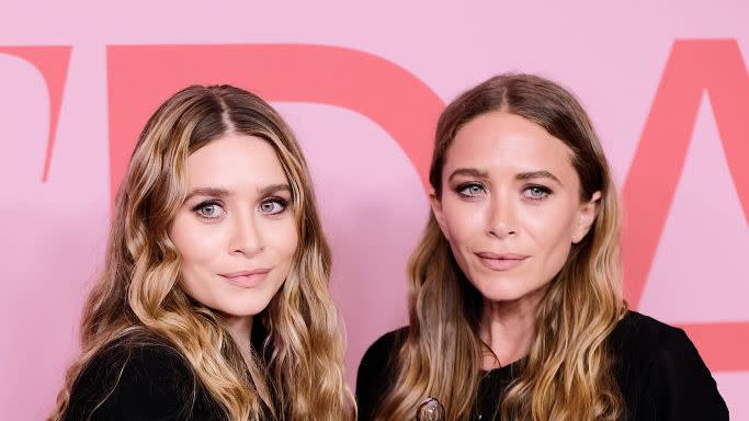 ashley and mary kate olsen holding a trophy from an award show