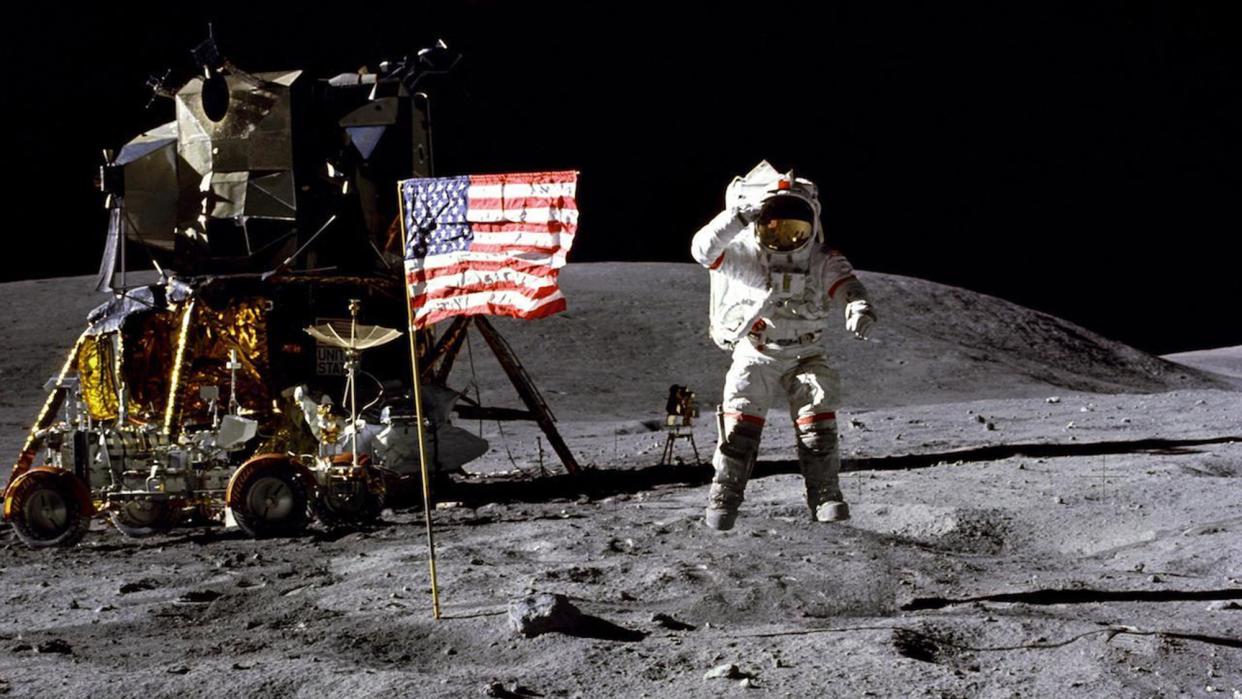 Apollo 16 lunar landing mission commander John W. Young leaps from the lunar surface as he salutes the United States flag. The flag is located at the Descartes landing site during the first Apollo 16 extravehicular activity.