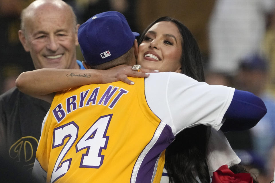 Vanessa Bryant, right, widow of Kobe Bryant, hugs Los Angeles Dodgers' Mookie Betts as Dodgers co-owner Stan Kasten looks on prior a baseball game between the Dodgers and the Atlanta Braves Friday, Sept. 1, 2023, in Los Angeles. (AP Photo/Mark J. Terrill)