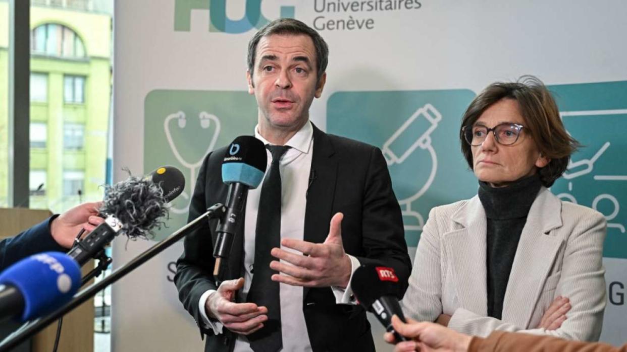 French Government's Spokesperson Olivier Veran (L) speaks to journalists next to French Junior Minister for Territories Organisation and Health Workers Agnes Firmin Le Bodo after a debate initiated by the French President on the subject of the end of life at the Geneva University Hospitals (HUG), on January 27, 2023. (Photo by Fabrice COFFRINI / AFP)