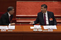 Chinese President Xi Jinping, right, chats with Wang Yang, chairman of the Chinese People's Political Consultative Conference (CPPCC) during the opening session of China's National People's Congress (NPC) at the Great Hall of the People in Beijing, Friday, March 5, 2021. Premier Li Keqiang has set a healthy economic growth target and vowed to make this nation self-reliant in technology amid tension with Washington and Europe over trade and human rights. (AP Photo/Andy Wong)