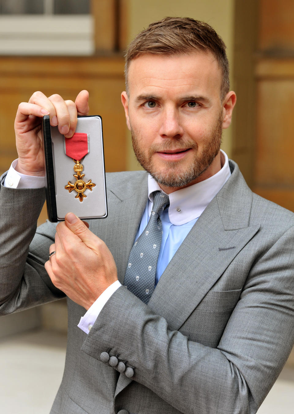 Gary Barlow holds his OBE, for services to the entertainment industry and to charity, which was awarded to him by Queen Elizabeth II during an Investiture ceremony at Buckingham Palace on November 21, 2012 in London, England. (Photo by John Stillwell/WPA Pool/Getty Images)