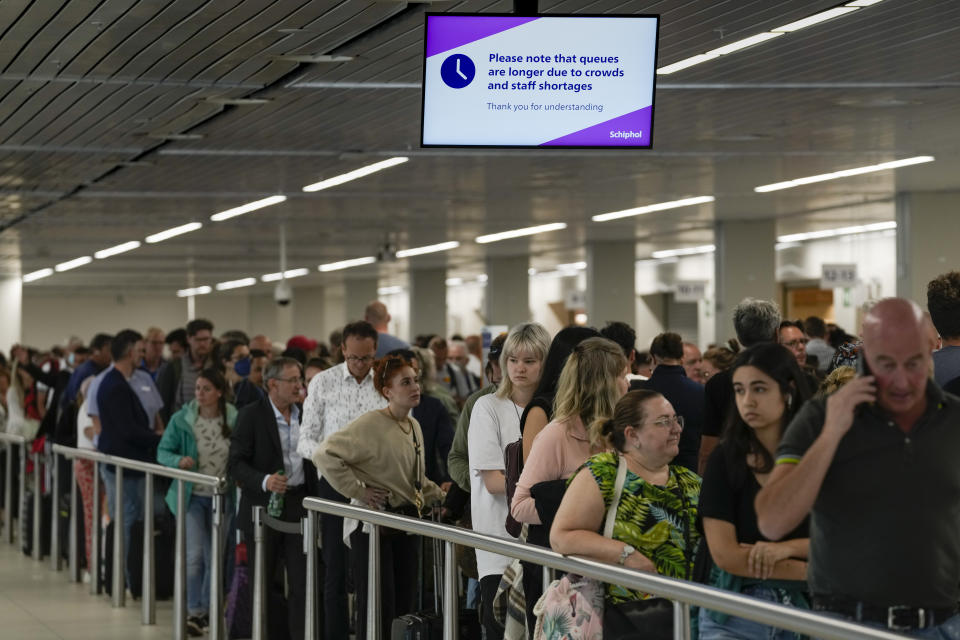 FILE - Travelers wait in long lines to check in and board flights at Amsterdam's Schiphol Airport, Netherlands, Tuesday, June 21, 2022. (AP Photo/Peter Dejong, File)