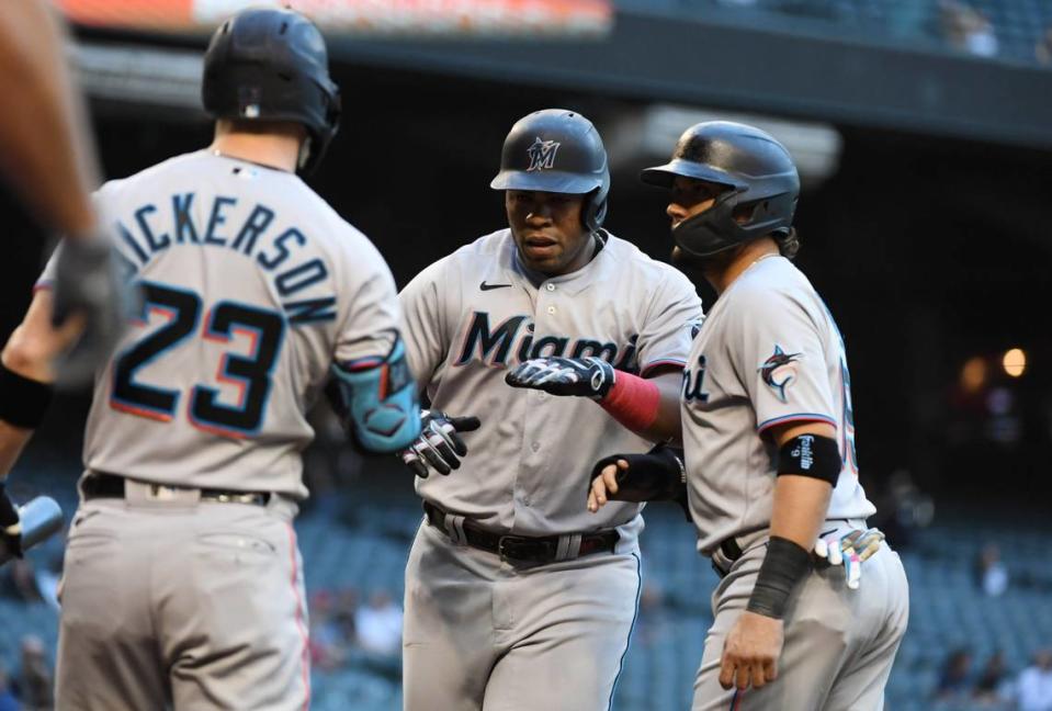 Jesus Aguilar #24 of the Miami Marlins celebrates with Brian Anderson #15 and Corey Dickerson #23 after hitting a two-run home run against the Arizona Diamondbacks during the first inning at Chase Field on May 12, 2021 in Phoenix, Arizona.
