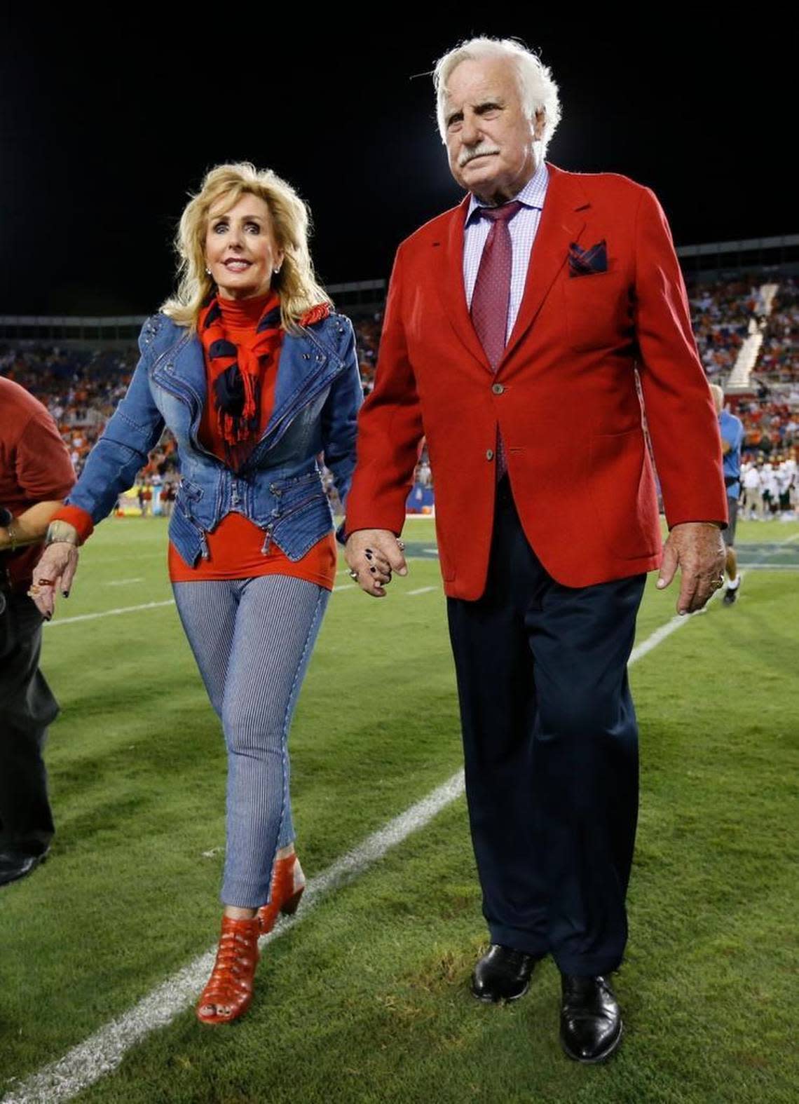 Howard Schnellenberger and wife Beverlee walk onto the field at FAU Stadium in Boca Raton on Friday, Sept. 11, 2015. The field at the stadium was named after Schnellenberger, who coached both the Miami Hurricanes and FAU Owls, who faced off Friday night.
