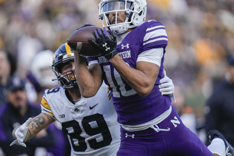 Northwestern defensive back Theran Johnson, right, intercepts a pass intended for Iowa wide receiver Nico Ragaini, left, during the first half of an NCAA college football game Saturday, Nov. 4, 2023, at Wrigley Field in Chicago. (AP Photo/Erin Hooley)