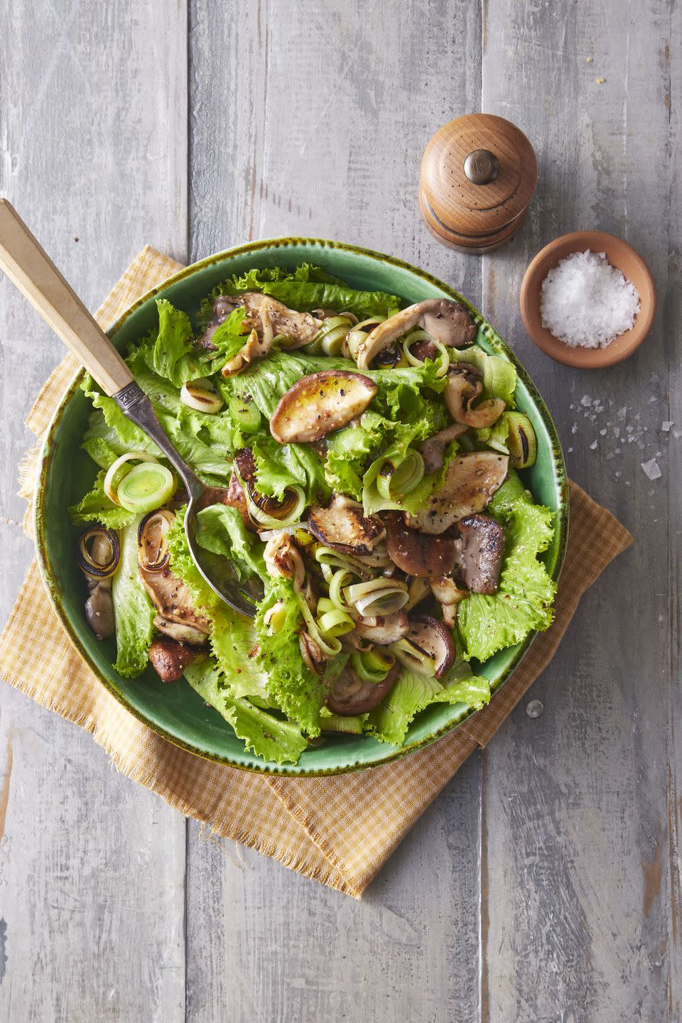 recipes leek mushroom and escarole salad in a large green bowl with a spoon for serving