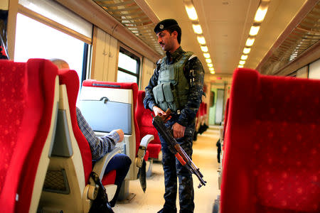 An Iraqi Policeman stands guard in a passenger cabin of the train on the way to Fallujah after leaving Baghdad Railway Station, the newly resurrected service to the city, in Baghdad, Iraq November 7, 2018. Picture taken November 7, 2018. REUTERS/Thaier al-Sudani