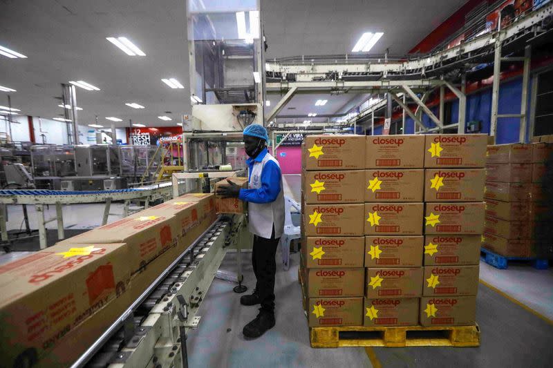 A worker stacks boxes of Closeup toothpaste produced at the Unilever factory in Lagos