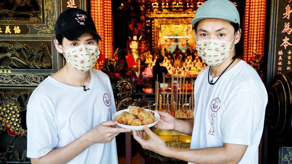 李玉璽（左）與黃鐙輝（右）將親自製作的陀螺炸雞帶到大溪普濟堂，感謝關聖帝君保庇。（東森電視、映畫提供）