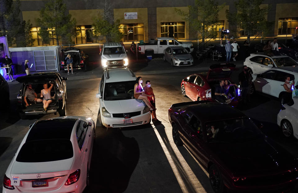 People watch a performance of "SEXXY: The Show" at an outdoor drive-in venue Friday, July 3, 2020, in Las Vegas. The producers and performers held the show over a few nights at the outdoor venue to raise money for charities while their regular showroom at the Westgate Las Vegas resort and casino was closed due to the coronavirus. (AP Photo/John Locher)