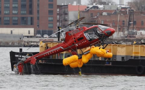 The wreckage of a chartered Liberty Helicopters helicopter that crashed into the East River is hoisted from the water in New York - Credit: Shannon Stapleton/Reuters