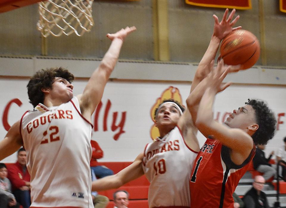 Durfee's Eric Lucas, right, goes up strong against Bishop Connolly's Alex Krynicki and Avery Dinham, during a recent game. Krynicki now has to consider where he will play next year, now that Bishop Connolly High School is closing.