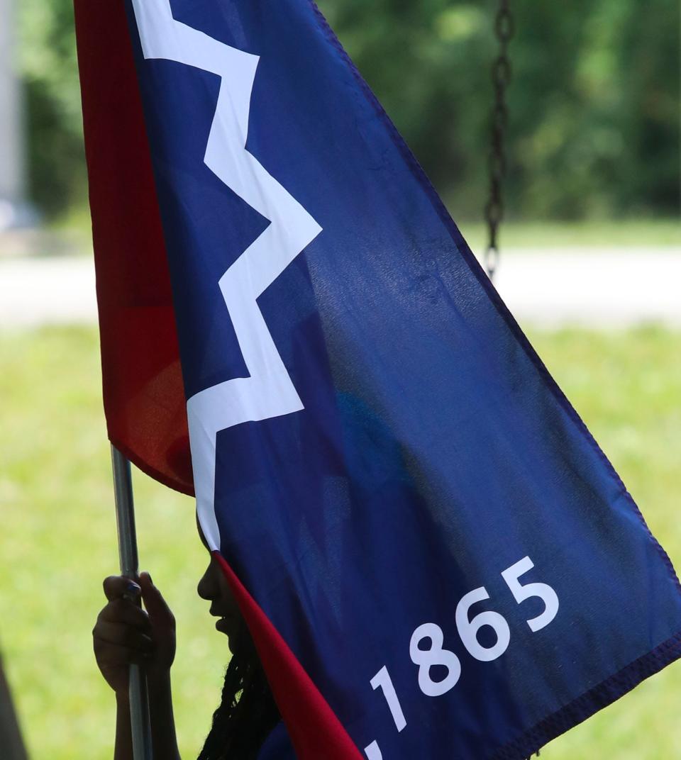 Makalyla Swain, 13, of Newark, carries a Juneteenth flag at the start of the Juneteenth celebration at the George Wilson Center and Park in Newark, Saturday June 17, 2023.