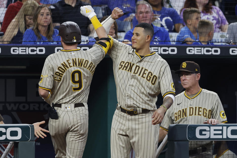 San Diego Padres manager Bob Melvin, right, looks on as Jake Cronenworth (9) celebrates with Manny Machado, center, after Cronenworth hit a home run during the third inning of baseball game against the Kansas City Royals in Kansas City, Mo., Friday, Aug. 26, 2022. (AP Photo/Colin E. Braley)