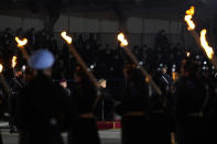 Chancellor Angela Merkel, center, attends in a Grand Tattoo ceremony to mark the farewell of her chancellorship in Berlin, Germany, Thursday, Dec. 2, 2021. With one week left before Merkel steps aside, she is being treated to a traditional send off involving the military ceremony with a brass band playing her choice of music. (AP Photo/Markus Schreiber)