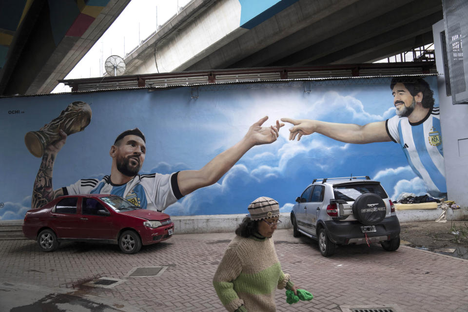 A mural of Argentina's soccer legends Lionel Messi, left, and Diego Maradona cover a wall at the low-income neighborhood of Padre Carlos Mugica in Buenos Aires, Argentina, Wednesday, Nov. 1, 2023. (AP Photo/Rodrigo Abd)