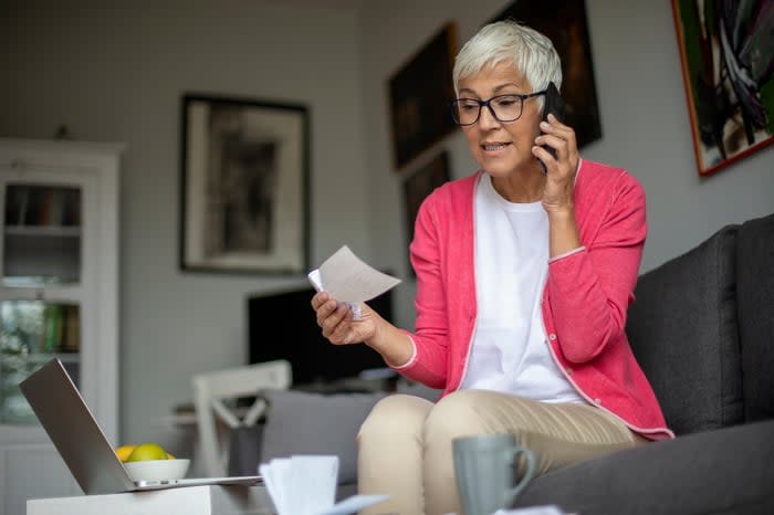 Person holding check and talking on phone.