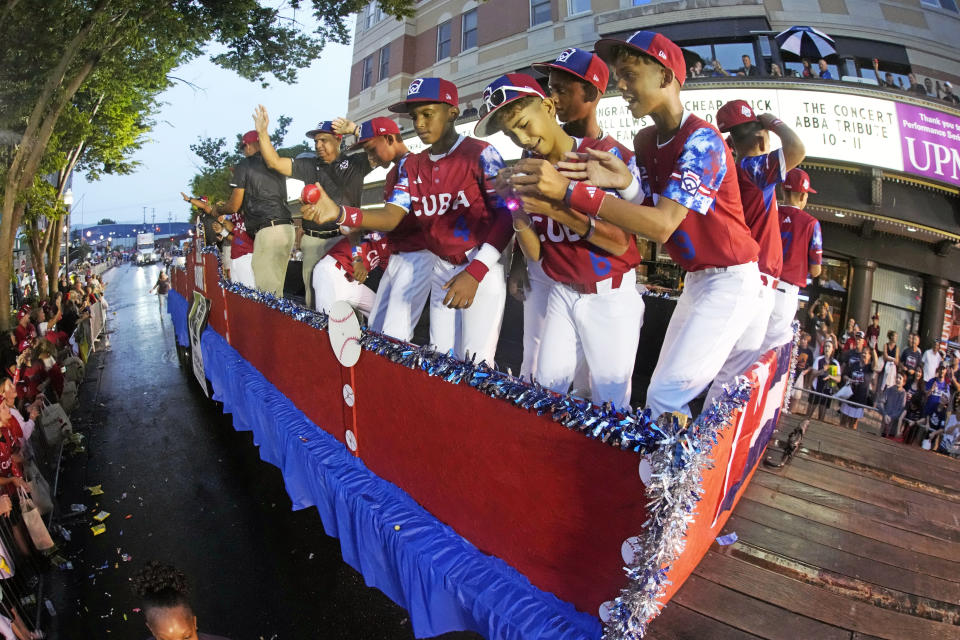 The Cuba Region champion Little League team from Bayamo, Cuba, rides in the Little League Grand Slam Parade in downtown Williamsport, Pa., Monday, Aug. 14, 2023. The Little League World Series baseball tournament, featuring 20 teams from around the world, starts later in week in South Williamsport, Pa. (AP Photo/Gene J. Puskar)