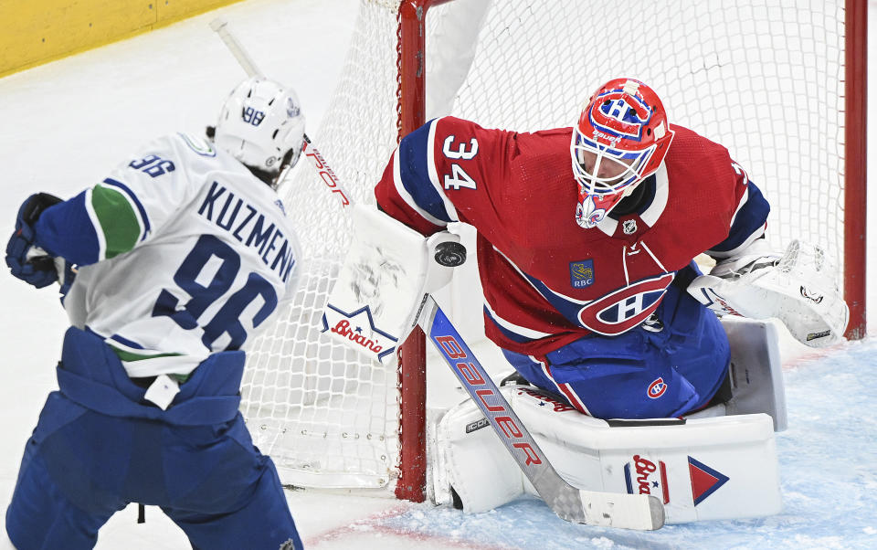 Montreal Canadiens goaltender Jake Allen, right, stops Vancouver Canucks' Andrei Kuzmenko (96) during second-period NHL hockey game action in Montreal, Sunday, Nov. 12, 2023. (Graham Hughes/The Canadian Press via AP)