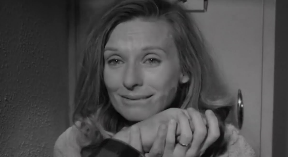 Woman smiling, resting head on hand, holding an award, in a black and white film still