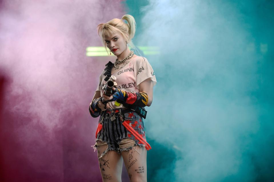 Harley in a t-shirt that says "harley quinn" with american flag jean shorts and suspenders falling down from the belt, as well as the same dog collars and necklaces from the last outfit